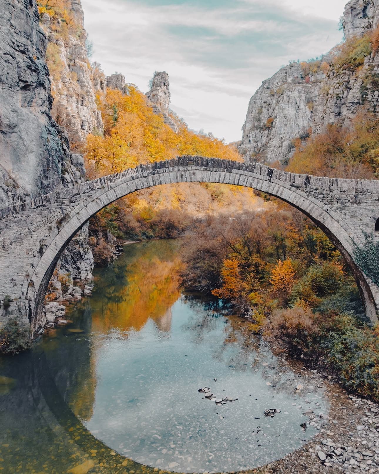 Ancient stone bridge in Zagori surrounded by autumn foliage, Epirus Greece
